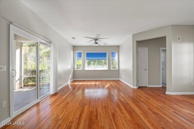 empty room featuring ceiling fan, a healthy amount of sunlight, and light wood-type flooring