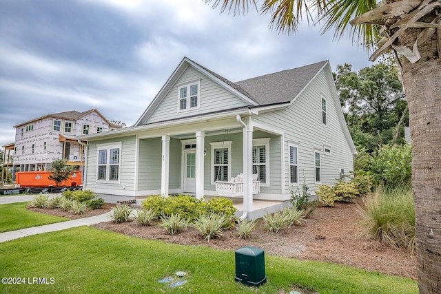 view of front of home featuring covered porch and a front lawn