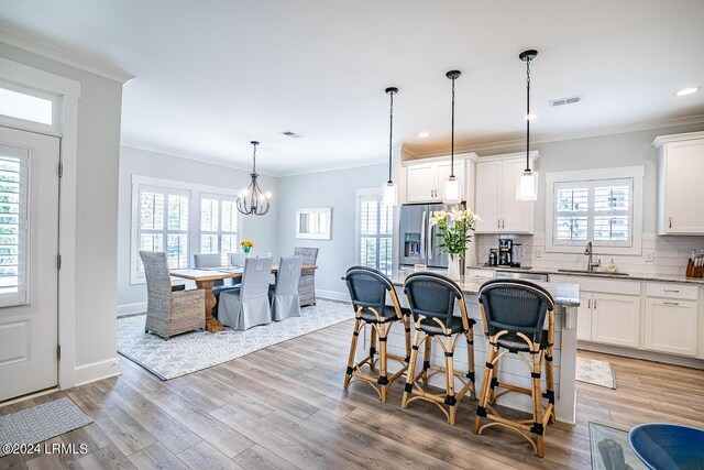 kitchen with a kitchen island, white cabinets, and stainless steel fridge with ice dispenser