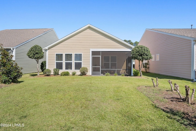 rear view of property featuring a lawn and a sunroom