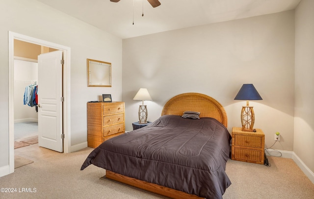 carpeted bedroom featuring ceiling fan, a spacious closet, and a closet