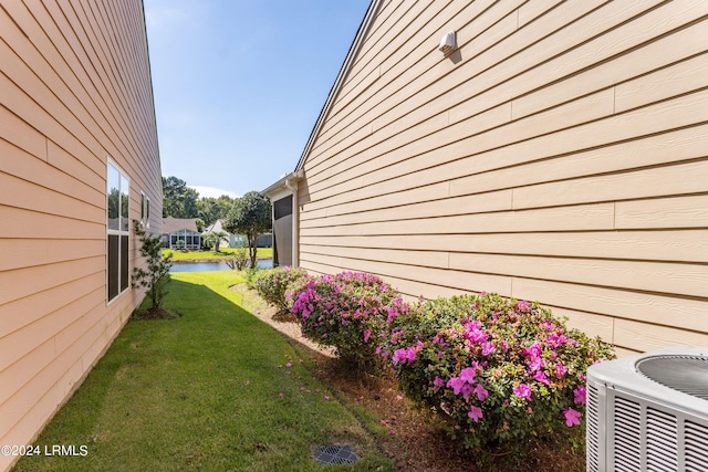 view of side of property with a yard and cooling unit