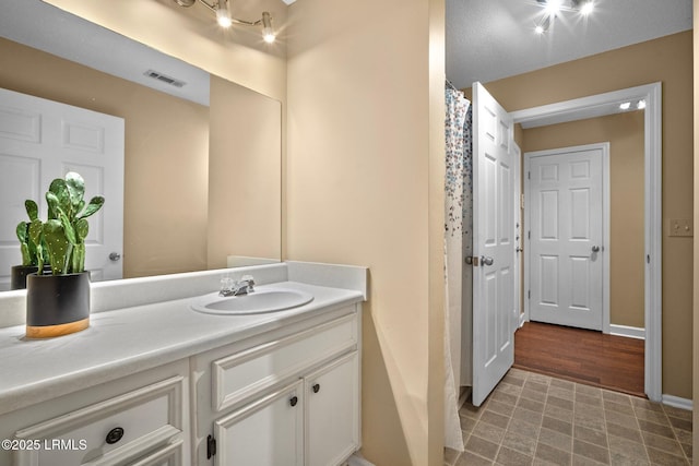 full bath featuring baseboards, vanity, tile patterned floors, and visible vents
