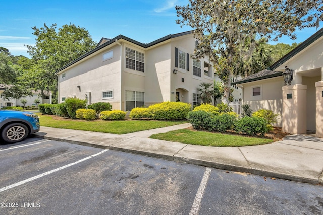 897 Fording Island Rd Unit 2708, Bluffton, SC 29910 - view of front facade featuring stucco siding and uncovered parking