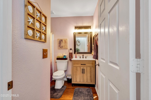 897 Fording Island Rd Unit 2708, Bluffton, SC 29910 - half bath with vanity, wood finished floors, toilet, and a textured wall