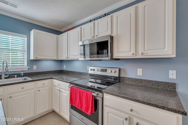 kitchen featuring stainless steel appliances, sink, a textured ceiling, and white cabinets