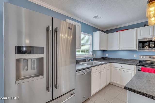 kitchen with sink, white cabinetry, a textured ceiling, light tile patterned floors, and stainless steel appliances