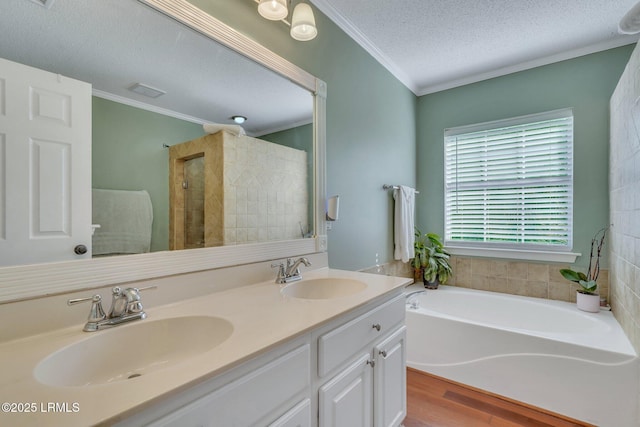 bathroom featuring vanity, hardwood / wood-style floors, ornamental molding, and a textured ceiling