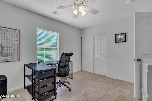 carpeted home office featuring ceiling fan and a textured ceiling