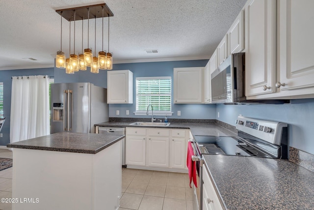 kitchen featuring stainless steel appliances, white cabinetry, a kitchen island, and sink