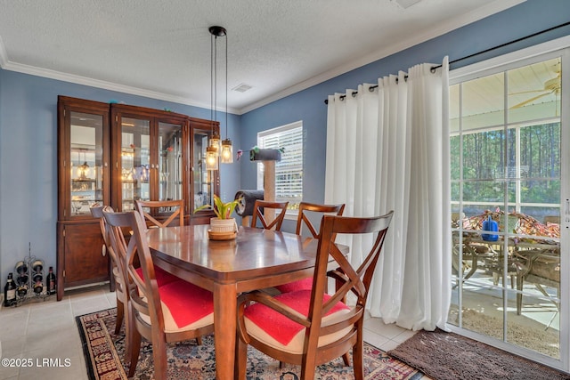 tiled dining space with ornamental molding and a textured ceiling