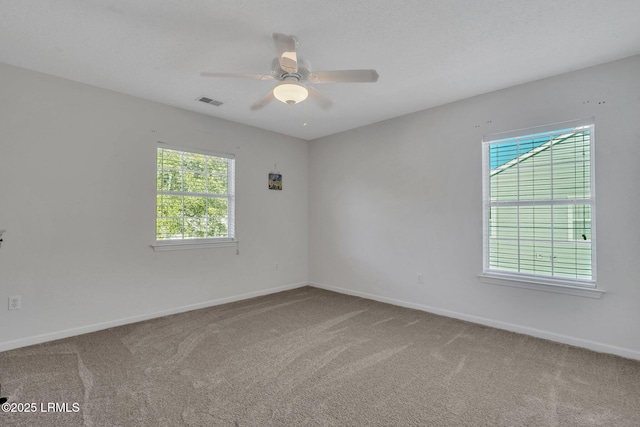 carpeted empty room with a wealth of natural light and ceiling fan