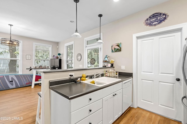 2654 Broad St, Beaufort, SC 29902 - kitchen with a sink, white dishwasher, a peninsula, white cabinetry, and light wood-style floors