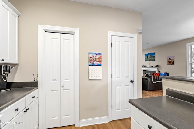 2654 Broad St, Beaufort, SC 29902 - kitchen with dark countertops, light wood finished floors, white cabinetry, and baseboards