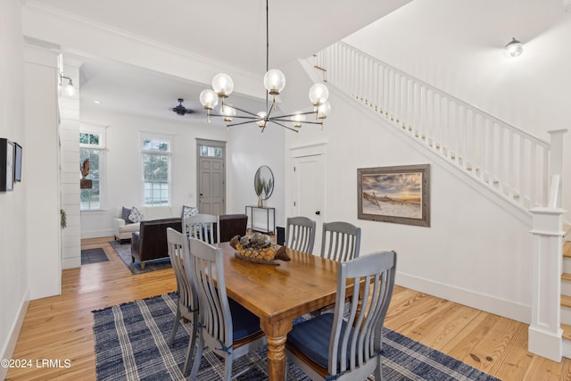 dining room with crown molding, light hardwood / wood-style flooring, and a notable chandelier