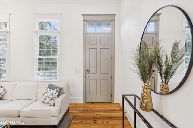 entryway featuring wood-type flooring and ornamental molding