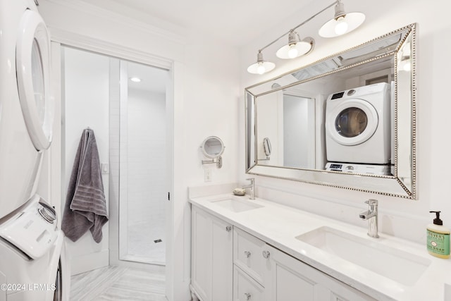 bathroom featuring vanity, stacked washer / drying machine, ornamental molding, and walk in shower