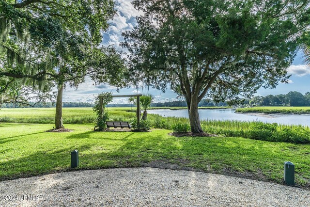 view of home's community with a water view and a yard