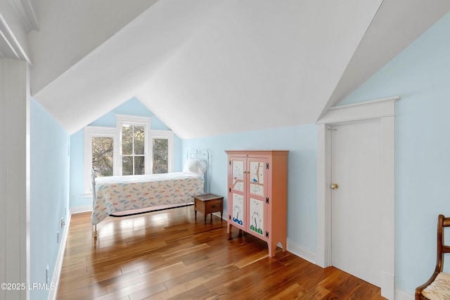 bedroom featuring lofted ceiling and wood finished floors