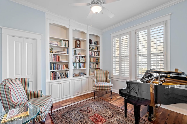 sitting room featuring ornamental molding, ceiling fan, baseboards, and wood finished floors