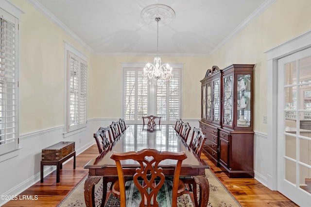 dining space featuring wood finished floors, a wealth of natural light, and a notable chandelier