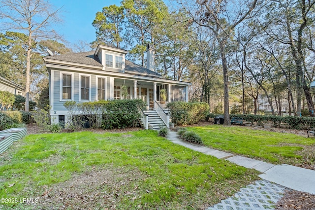 view of front of home featuring a front yard, covered porch, and a chimney