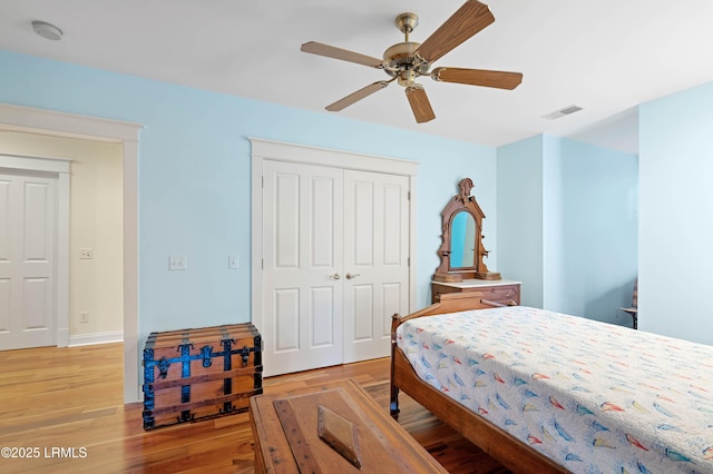 bedroom with a closet, light wood-type flooring, a ceiling fan, and baseboards