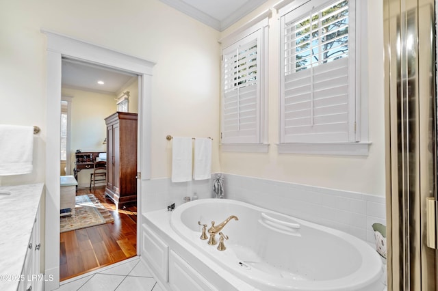 bathroom with ensuite bath, tile patterned floors, crown molding, vanity, and a bath