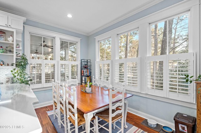 dining area featuring dark wood-style floors, baseboards, a ceiling fan, and crown molding