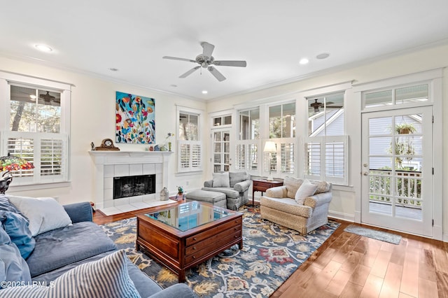 living area featuring ornamental molding, a ceiling fan, and wood finished floors