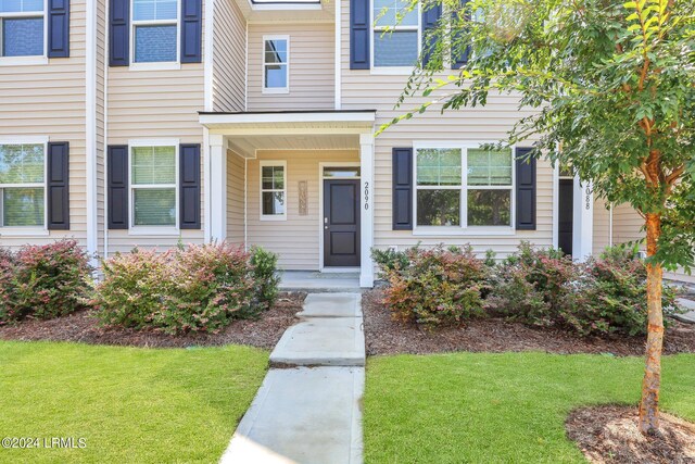 doorway to property with a lawn