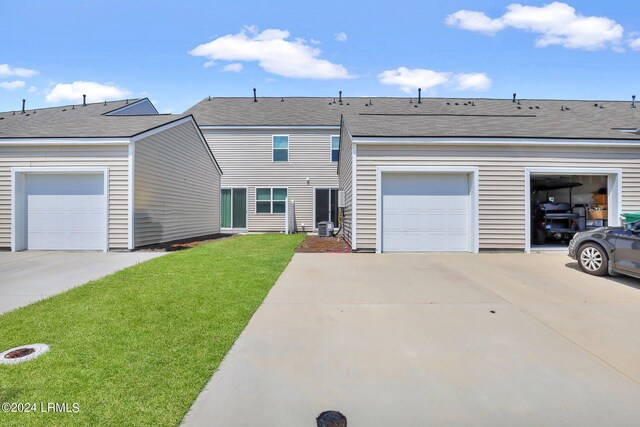 view of front of property with a garage, central AC, and a front yard