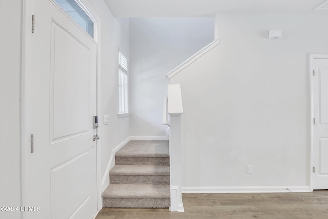 stairs featuring hardwood / wood-style flooring