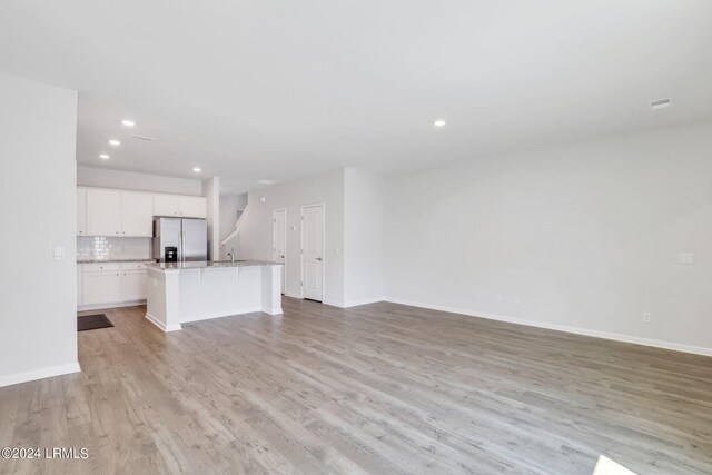 unfurnished living room with sink and light wood-type flooring