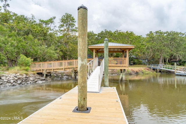 view of dock with a gazebo and a water view