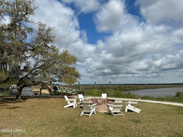 view of yard with a fire pit and a water view