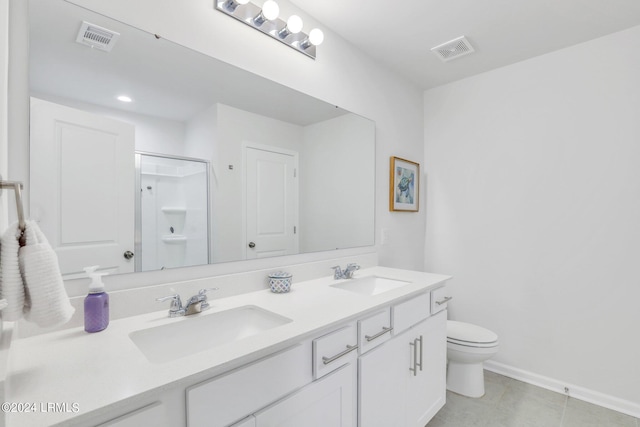 bathroom featuring a shower with door, vanity, tile patterned floors, and toilet