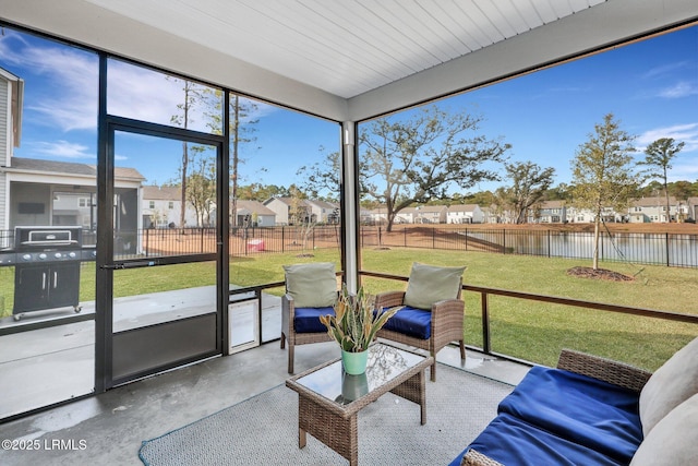 sunroom / solarium featuring a water view and a wealth of natural light