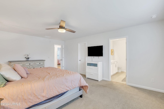 bedroom with ceiling fan, ensuite bathroom, and light colored carpet