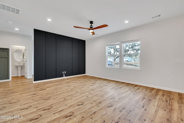 unfurnished bedroom featuring ensuite bathroom, ceiling fan, and light hardwood / wood-style floors