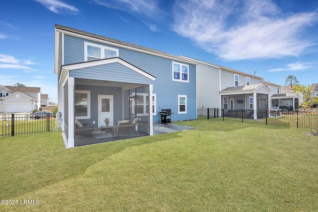 rear view of property featuring a sunroom, a patio area, and a lawn