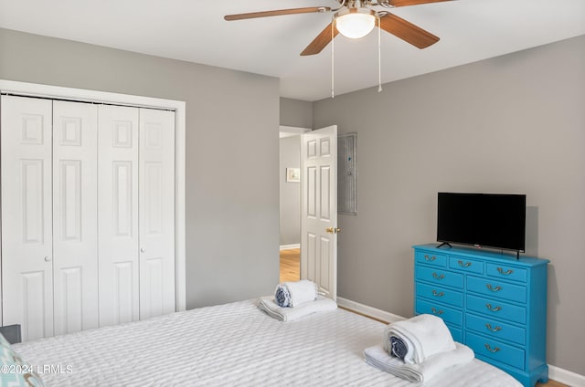 bedroom with baseboards, a ceiling fan, a closet, and wood finished floors
