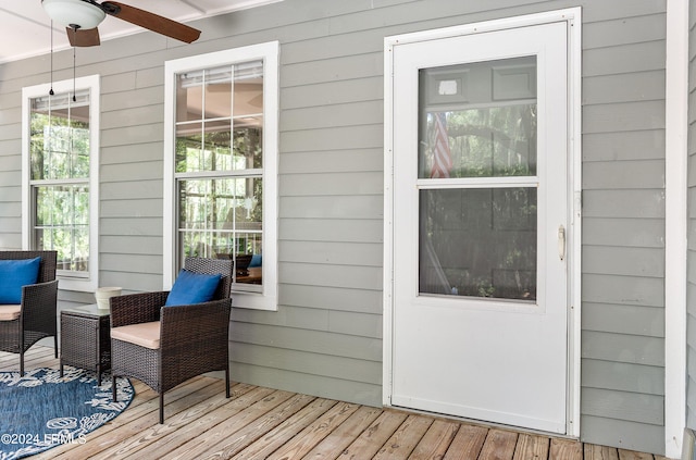 entryway with light wood-style floors, a ceiling fan, and wood walls