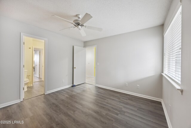 103 Battery Ln, Beaufort, SC 29902 - unfurnished bedroom featuring multiple windows, wood finished floors, a textured ceiling, and baseboards