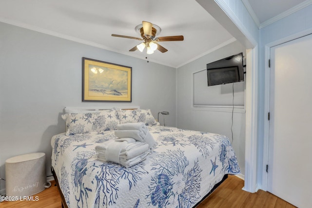 bedroom with ornamental molding, a ceiling fan, and wood finished floors