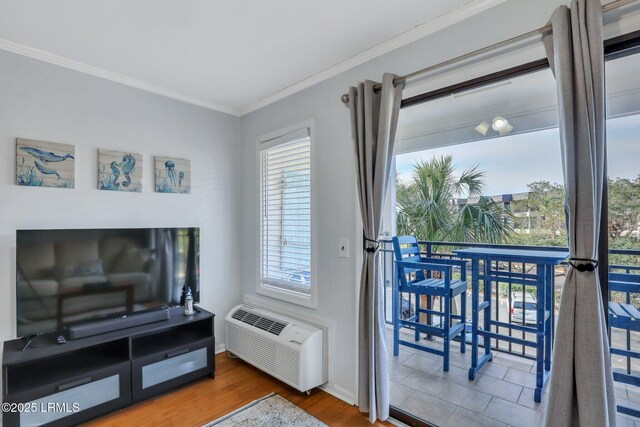 living area with ornamental molding, a wall mounted air conditioner, baseboards, and wood finished floors