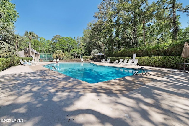 community pool featuring a patio and fence