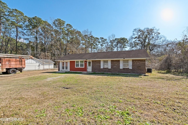 ranch-style home with a front lawn and french doors