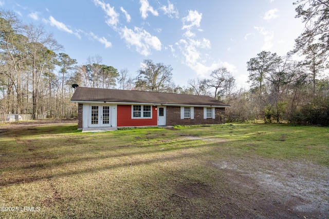 ranch-style home with brick siding, a front lawn, and french doors