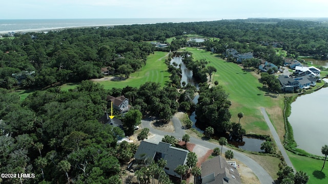 aerial view of property's location with a large body of water, a golf course, nearby suburban area, and a heavily wooded area